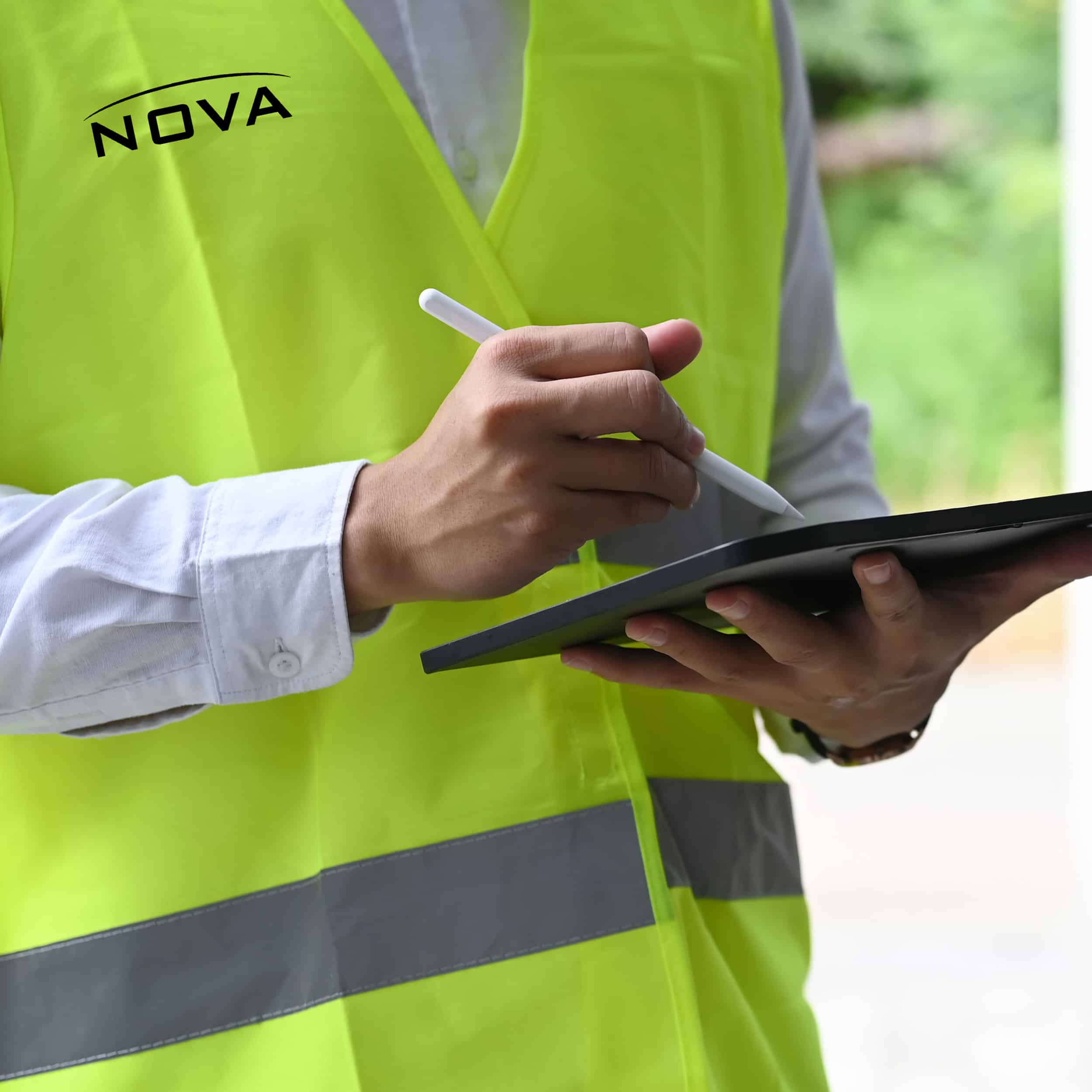 a hand holding a cellphone and wearing a green shirt