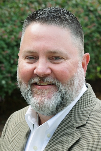 a close up of a man wearing a suit and tie