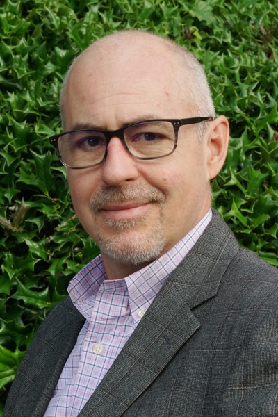 a man wearing glasses posing for the camera