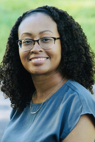 a person wearing glasses and smiling at the camera