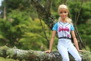 Barbie standing next to a tree