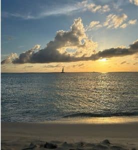 a sandy beach next to a body of water